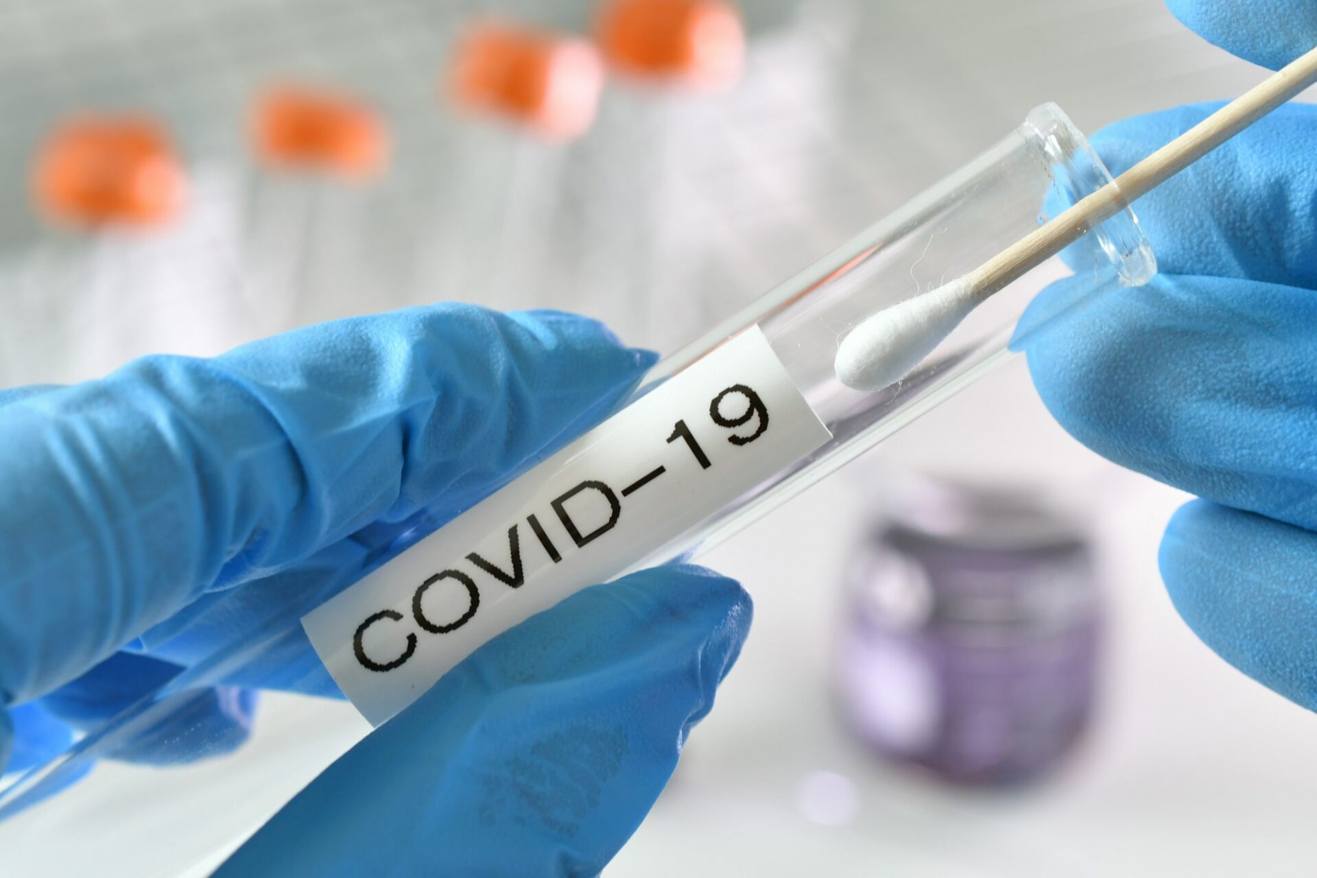 Testing swab being inserted test tube labeled Covid-19 in a lab, laboratory to get results.